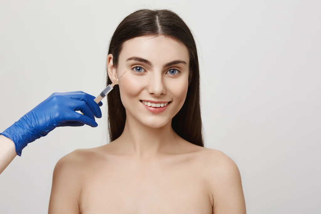 A close-up, candid-style shot of a cheerful woman at an aesthetic clinic like Luveen Clinic receiving Autologous Stem Cell Injection for rejuvenation.