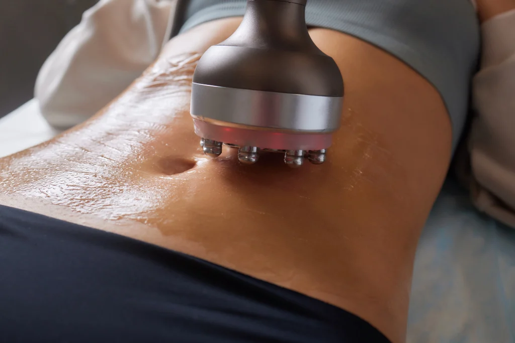 Procedure removing cellulite on female abdomen, cavitation belly massage. Ultrasonic massage for weight loss. A slimming treatment to correction of female figure without surgical intervention.